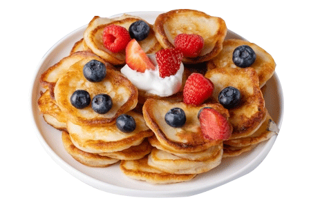 Fluffy mini pancakes topped with blueberries, raspberries, strawberries, and a dollop of whipped cream